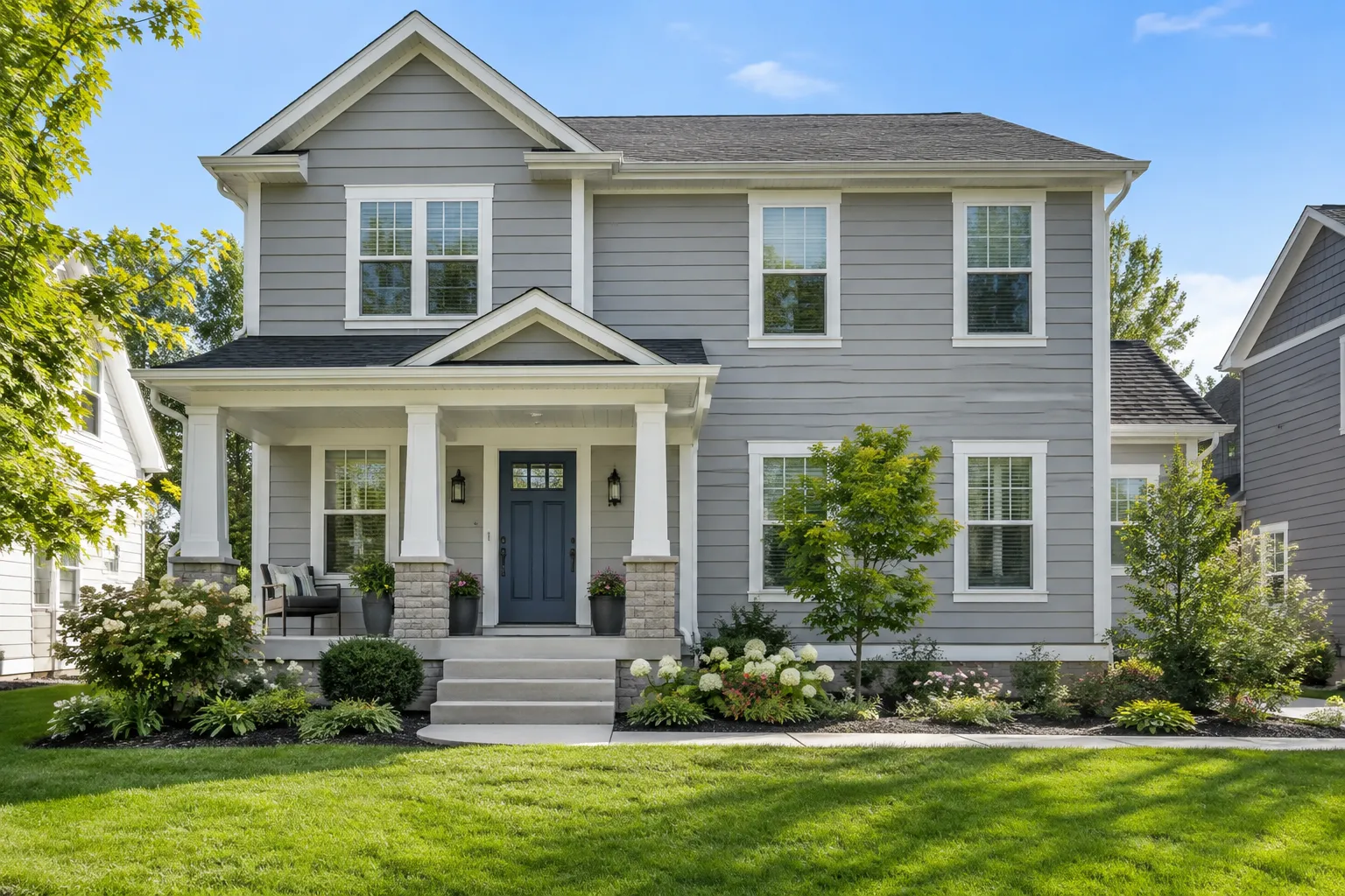 Freshly painted residential home with gray siding and navy front door